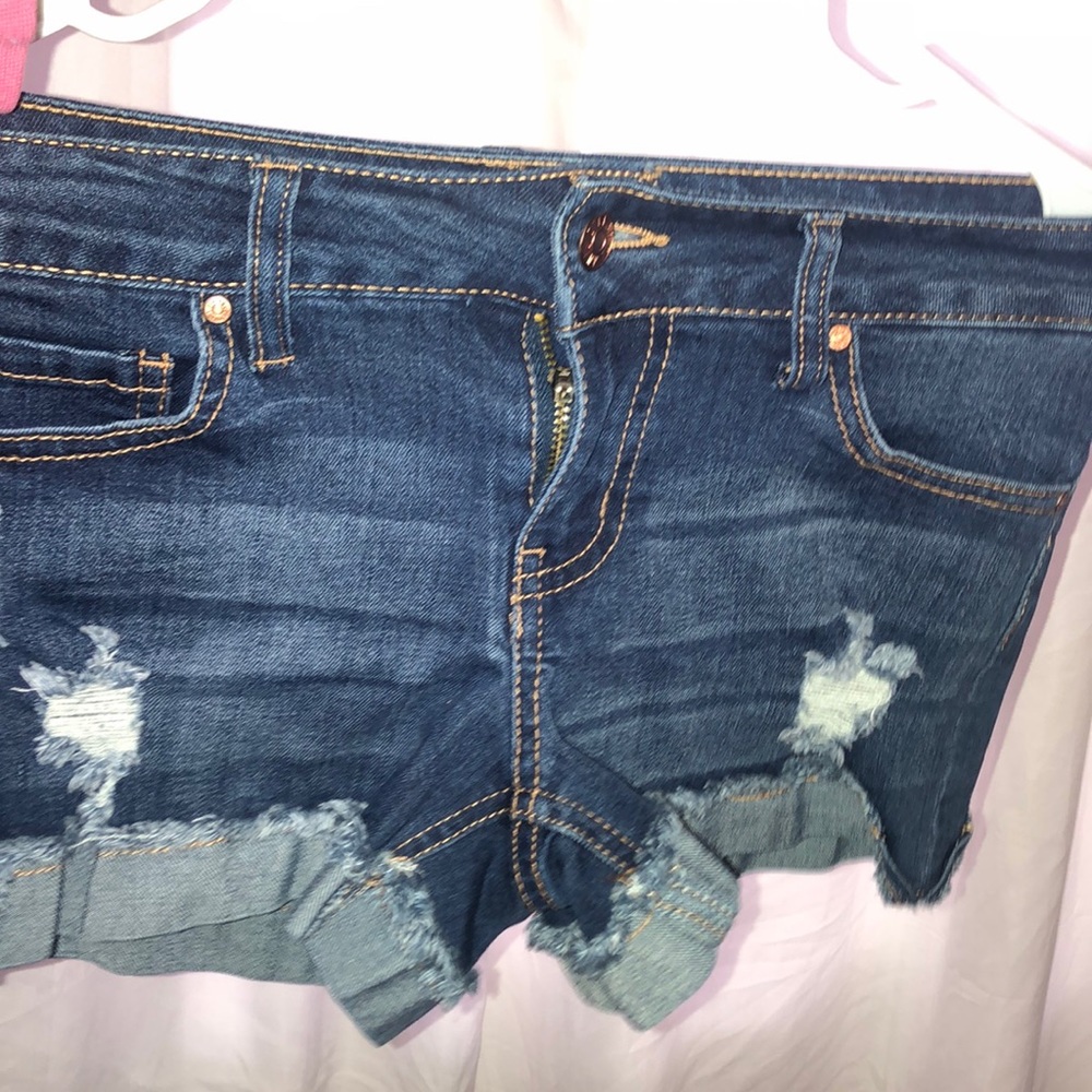 Dark blue ripped shorts with brown stitching